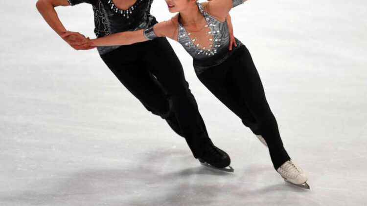 Pasangan seluncur indah melakukan gerakan lift yang spektakuler